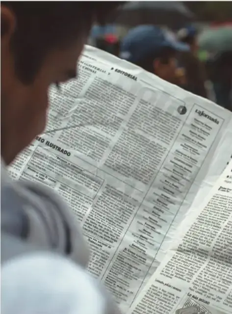 Persona leyendo un periódico con encabezados sobre presupuesto y gasto público, símbolo del acceso a la información.