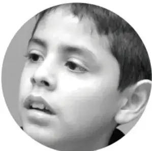 Fotografía en blanco y negro de un niño con la boca abierta, como si estuviera hablando o respirando.