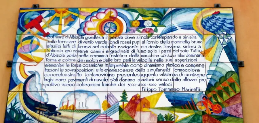 Fotografía de un mural realizado en azulejos de cerámica con un texto futurista de Marinetti sobre la máquina, la velocidad y el color, firmado 'Filippo Tommaso Marinetti'.