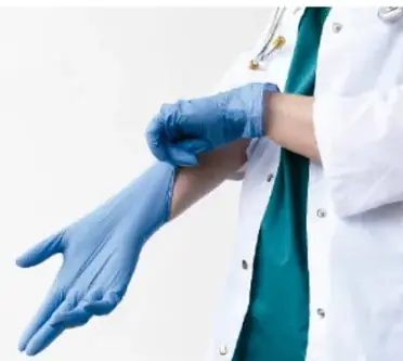 Profesional de salud se coloca guantes de látex azules, ilustrando medidas de protección para la vía sanguínea.