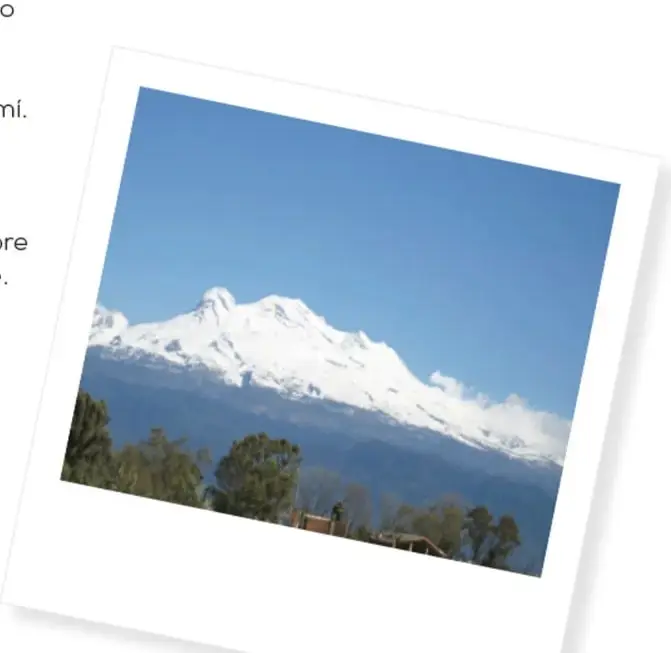 Fotografía de un paisaje nevado con montañas y árboles, enmarcada como una polaroid.