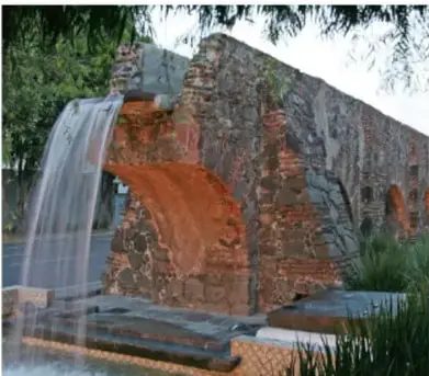 Fotografía de una fuente o cascada artificial construida con roca, que representa visualmente el uso y aprovechamiento del agua.