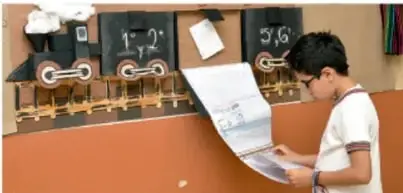 Niño revisando un periódico mural sobre la Revolución Mexicana con un tren y figuras.