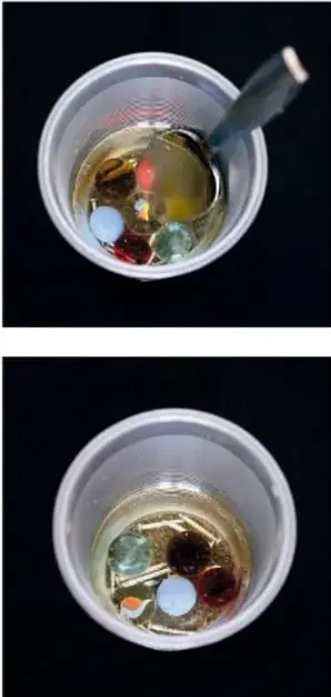 Vaso con la mezcla tras el reposo, donde se distinguen el aceite en la superficie y los sólidos en el fondo.