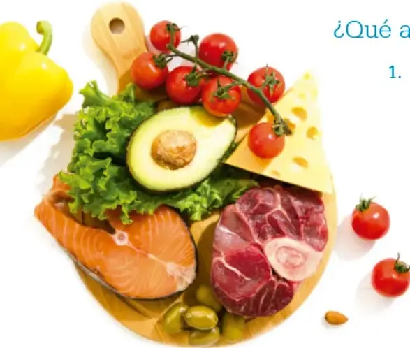 Tabla de madera con verduras, frutas, queso, salmón y carne: muestra la variedad de grupos alimenticios.