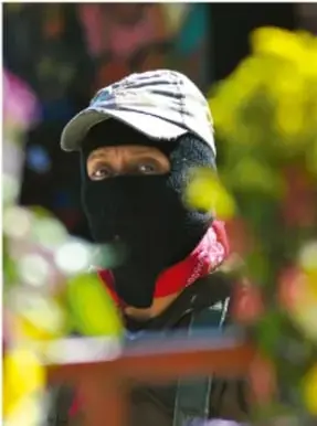Fotografía de una persona enjugándose el rostro con un pañuelo rojo y gorra clara; el rojo alude al pañuelo zapatista.