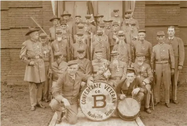 Fotografía histórica de un grupo de veteranos confederados con un tambor que dice 'Confederate Veterans Co. B Nashville Tenn'.