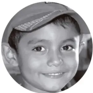 Retrato circular de un niño sonriente con gorra, probablemente un estudiante.