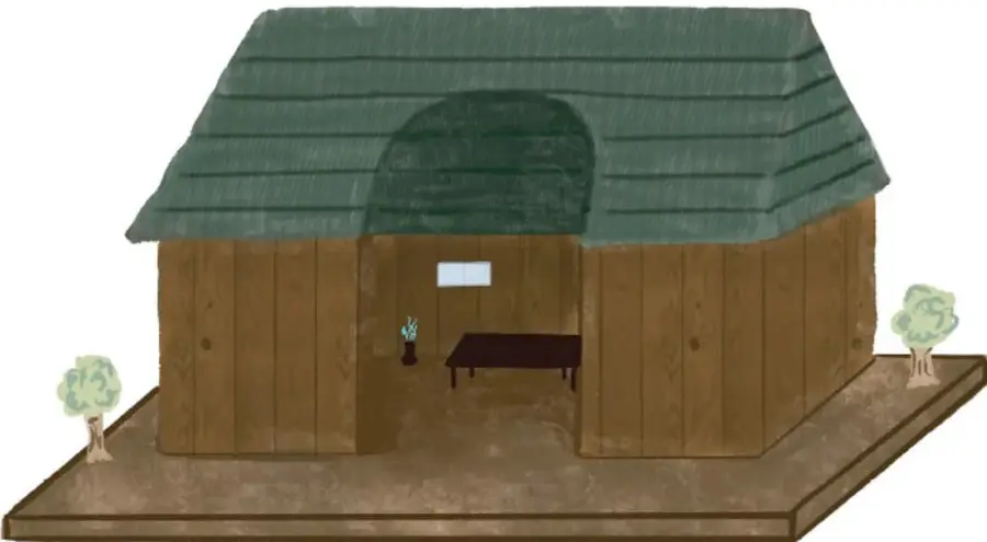 Maqueta de una casa de madera con techo verde a dos aguas, puerta con arco, mesa y jarrón con flores en el interior, sobre una base de tierra con dos árboles pequeños a los lados. Crédito: Luz Fernanda Jacinto Rodero, Ciudad de México.