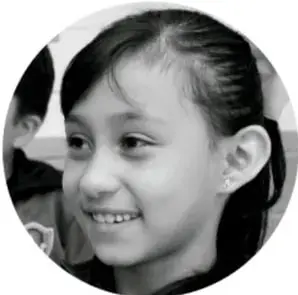 Fotografía circular de una niña sonriente, estudiante de primaria.