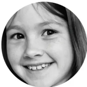Fotografía en blanco y negro del rostro sonriente de una niña.