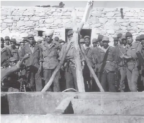 Fotografía de un grupo de soldados o milicianos armados en un paisaje árido, posiblemente durante la guerra de Argelia.