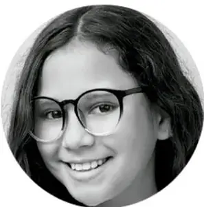 Fotografía de una niña sonriente con lentes.