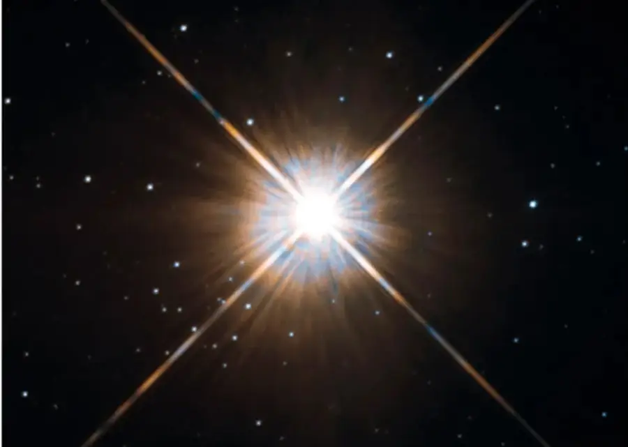 Fotografía astronómica de Próxima Centauri: estrella muy brillante con destellos en cruz sobre un fondo de estrellas pequeñas.