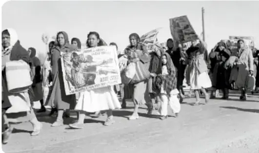 Mujeres marchando con pancartas y niños, probablemente en la Marcha del Hambre.