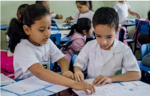 Niños trabajando en equipo sobre una maqueta.