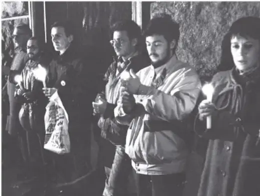 Fotografía en blanco y negro de un grupo de personas, aparentemente ciudadanos soviéticos, formados en una fila con bolsas, posiblemente esperando suministros.