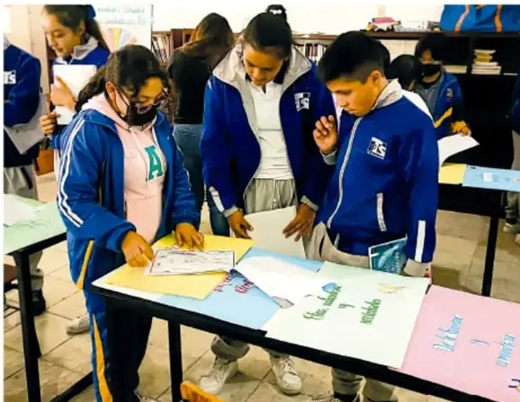 Fotografía de estudiantes de telesecundaria trabajando con su mapa local sobre una mesa; crédito: Luis Eduardo García Medel, Tlaxcala.