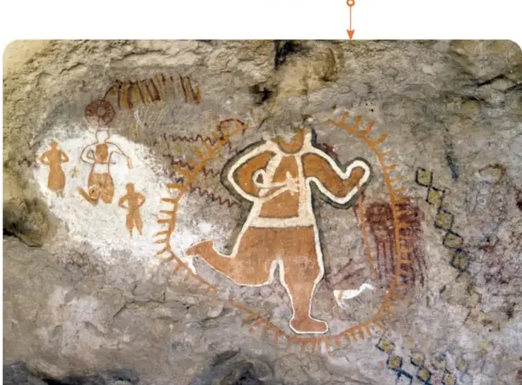 Pintura rupestre de la Cueva La Pintada, Sierra de San Francisco, Baja California Sur: grupo de figuras humanas pintadas en tonos rojizos sobre fondo rocoso.