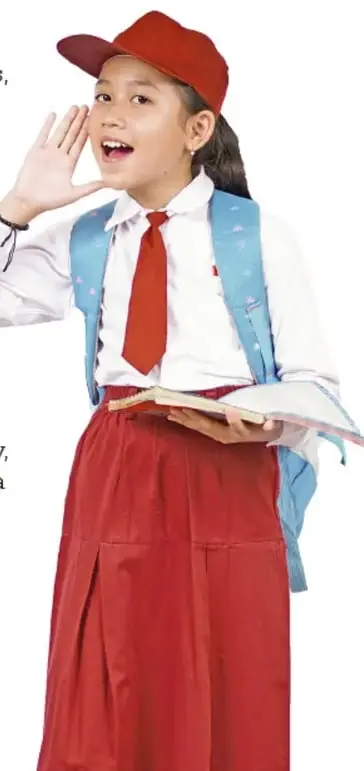 Niña con uniforme escolar (falda roja, camisa blanca, corbata roja y gorra roja) que hace mímica con la mano junto a la boca, como si gritara o llamara.