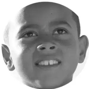 Fotografía en blanco y negro del rostro sonriente de un niño.