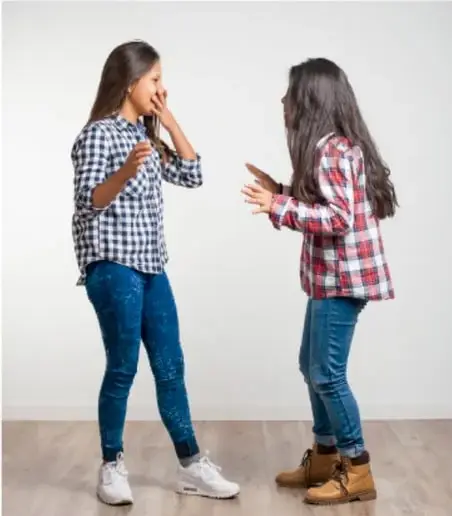 Dos jóvenes conversando de forma animada, mostrando la función emotiva y fática del lenguaje.
