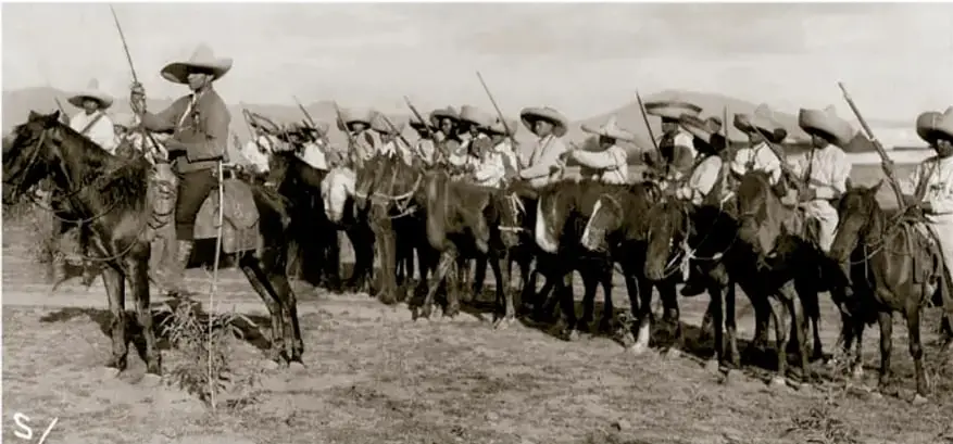 Fotografía histórica en sepia del Pelotón del Ejército Libertador, 1911: grupo de jinetes campesinos con sombreros y arreos, montados a caballo, custodiando un campo. Manning Texas and Mexico Collection, Biblioteca de la Universidad Metodista del Sur, EE. UU.