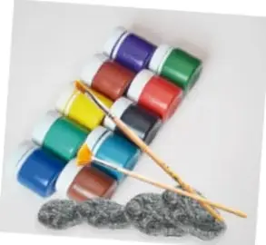 Fotografía de materiales: frascos de pintura acrílica de colores, pinceles y piedras de diversas formas.