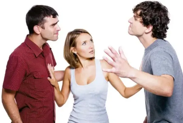 Fotografía de tres jóvenes: dos hombres discuten con gestos y expresiones de confrontación mientras una mujer intermedia intenta separarlos y mediar, ilustrando la situación de conflicto y mediación.
