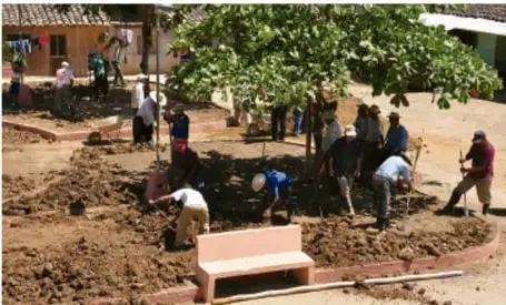 Fotografia de un grupo de personas trabajando en una obra o proyecto comunitario al aire libre, ilustrando la puesta en practica de tareas productivas.