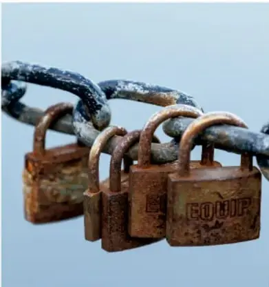Fotografía de cadenas metálicas oxidadas con varios candados cerrados, en tonos azul y café.
