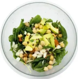 Fotografía de un tazón con ensalada verde que contiene espinaca, garbanzo y pedacitos de jitomate, como ejemplo de platillo saludable.