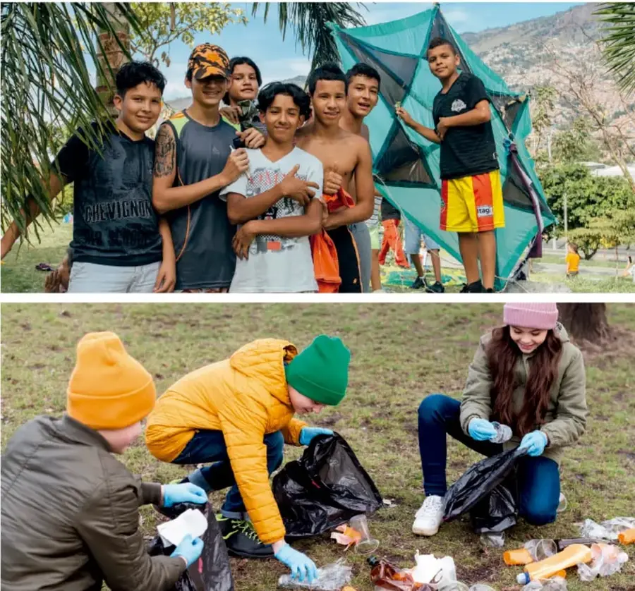 Grupo de jóvenes sonrientes colaborando en el montaje de carpas o estructuras textiles en un parque con palmeras.