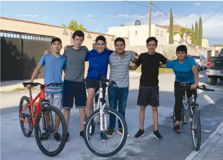 Fotografía de seis adolescentes de Telesecundaria posando juntos en la calle con sus bicicletas, mostrando convivencia y actividad comunitaria.