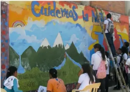 Estudiantes observan y participan en la pintura de un mural comunitario con el texto 'Cuidemos la naturaleza'.