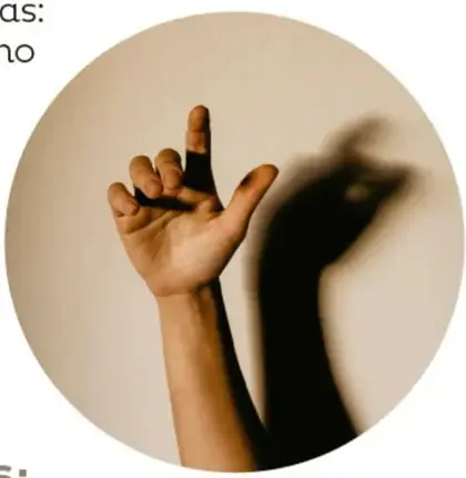 Mano alzada con dedos extendidos proyectando sobre la pared una sombra con zona oscura (umbra) y zona tenue (penumbra).