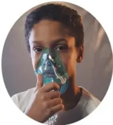 Fotografía de un niño utilizando una mascarilla o inhalador, ilustrando el cuidado del sistema respiratorio.