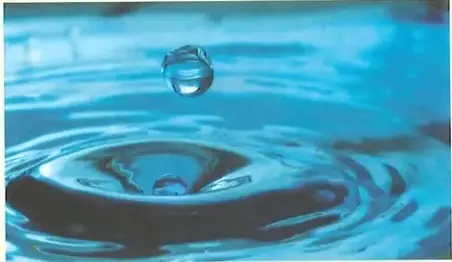 Fotografía de agua en movimiento y una gota, que representan el estado líquido.
