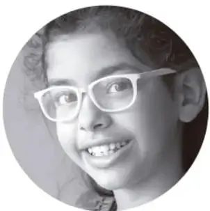 Fotografía de una niña con lentes sonriendo.