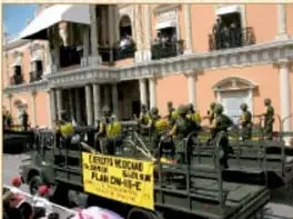 Fotografía de personal militar con equipo de protección y mochilas con la leyenda 'Plan DN-III-E'.