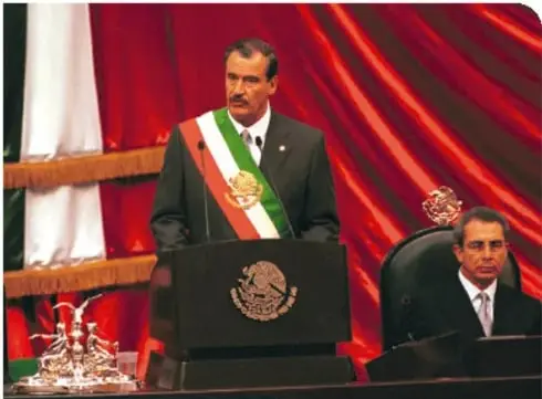 Fotografía de Vicente Fox Quesada con banda presidencial en un acto oficial.