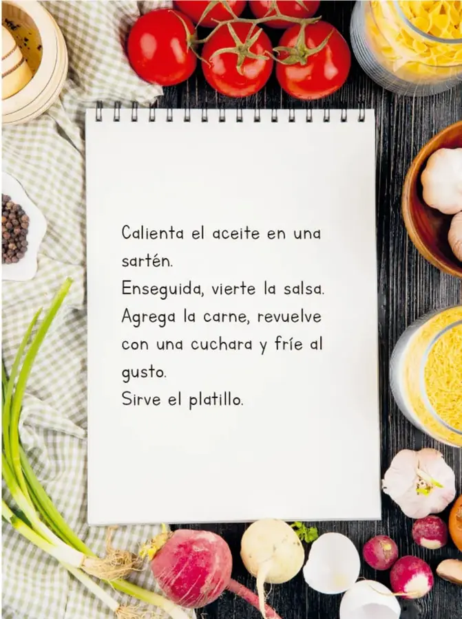 Fotografía cenital de ingredientes de cocina (jitomates, ajo, cebollín, rábanos, pasta) alrededor de un cuaderno espiralado blanco con una receta escrita a mano en letras de imprenta.