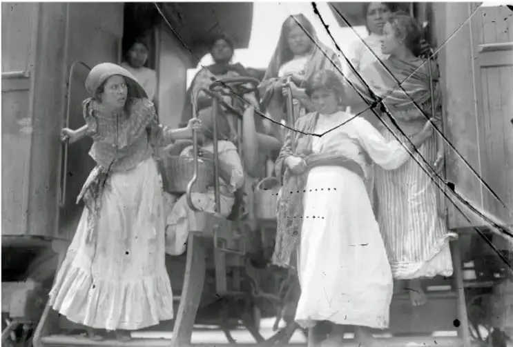 Fotografía histórica en blanco y negro de un grupo de mujeres subiendo a un tren durante la Revolución mexicana.