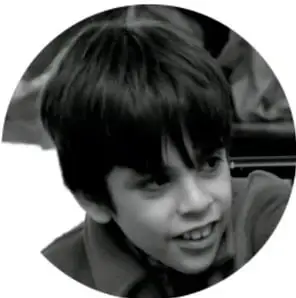 Fotografía en blanco y negro de un niño sonriente, ilustrativa del trabajo comunitario.