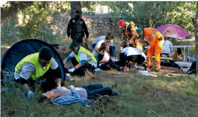 Fotografía de un grupo de rescatistas y paramédicos atendiendo a personas en un área natural durante una emergencia.