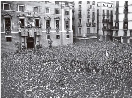 Fotografía en blanco y negro de una multitud reunida frente a un edificio de gobierno con balcones, probablemente durante una manifestación o proclamación republicana.