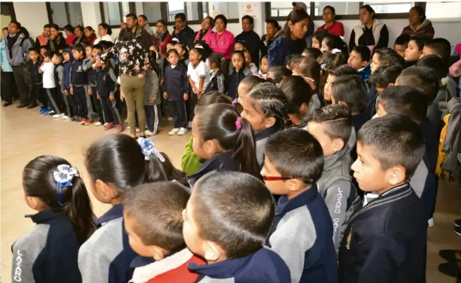 Fotografía de una comunidad escolar reunida en un patio, con estudiantes y adultos formando un círculo doble durante una actividad de diálogo.