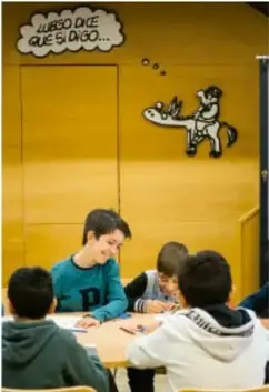 Grupo de estudiantes conversando alrededor de una mesa.