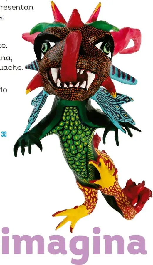 Fotografía grande de un alebrije de cartón: ser alado con cabeza ancha pardusca punteada de rojo, ojos verdes, cuernos rojos y verdes, alas azules con grecas, torso verde con textura de escamas amarillas y rojas, brazos verdes con manos de dedos largos y patas rojas y amarillas con textura de plumas.