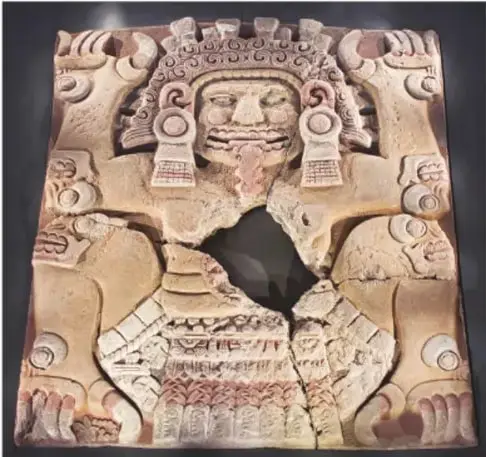 Fotografía del monolito de Tlaltecuhtli, tallado en piedra rosada, con la deidad en posición de parto y una fractura central.